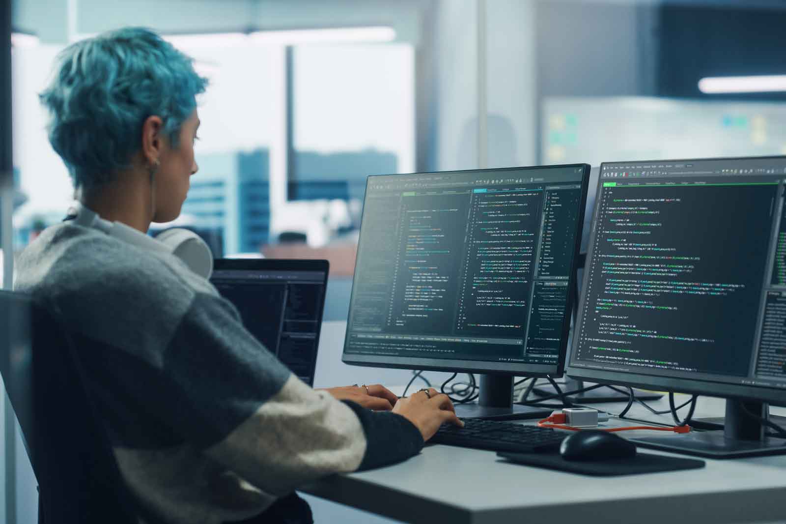 Female Programmer is Working on Desktop Computer, Screen Shows Coding Language User Interface. 