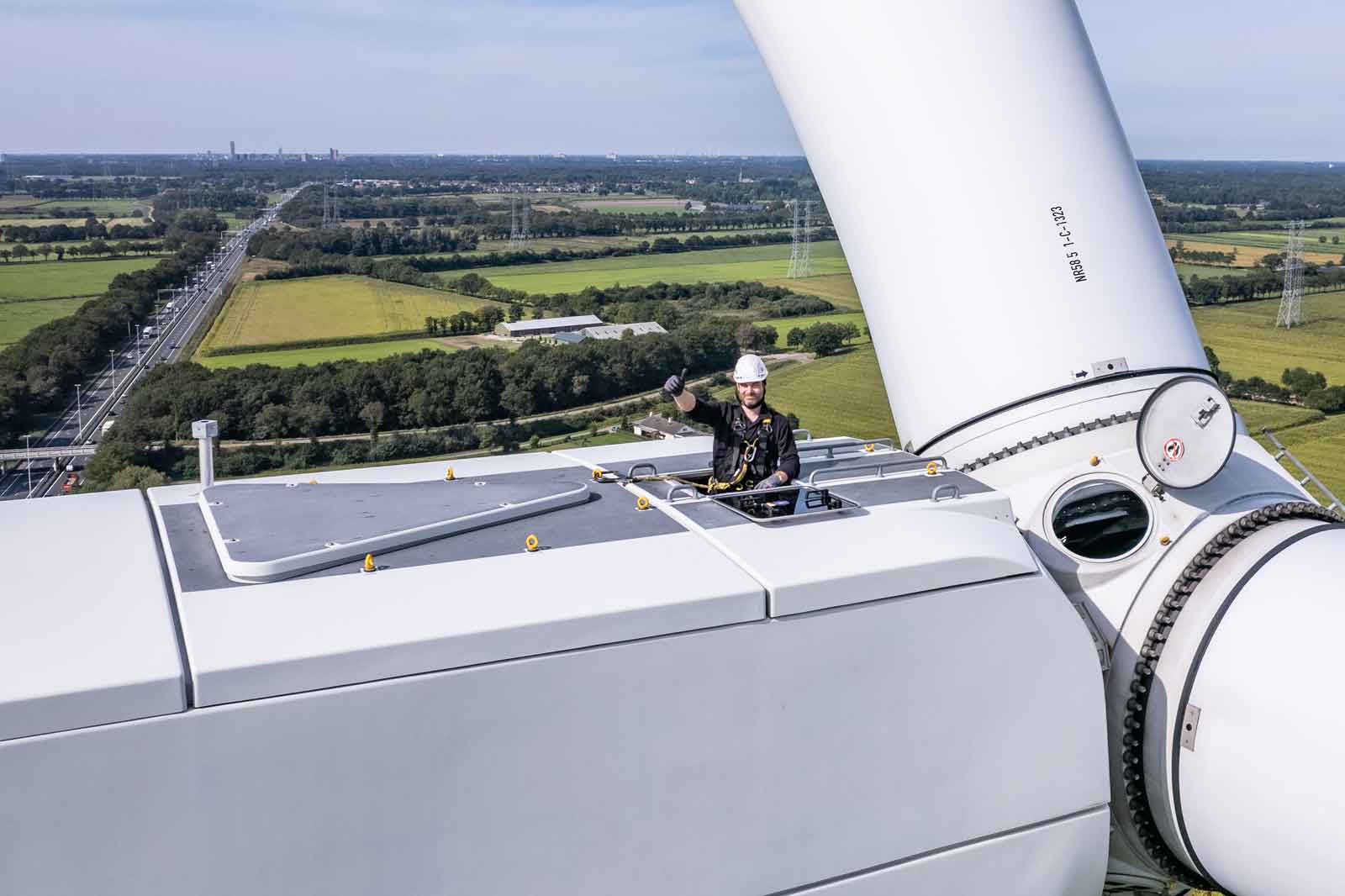 Man looking out on top of onshore wind turbine