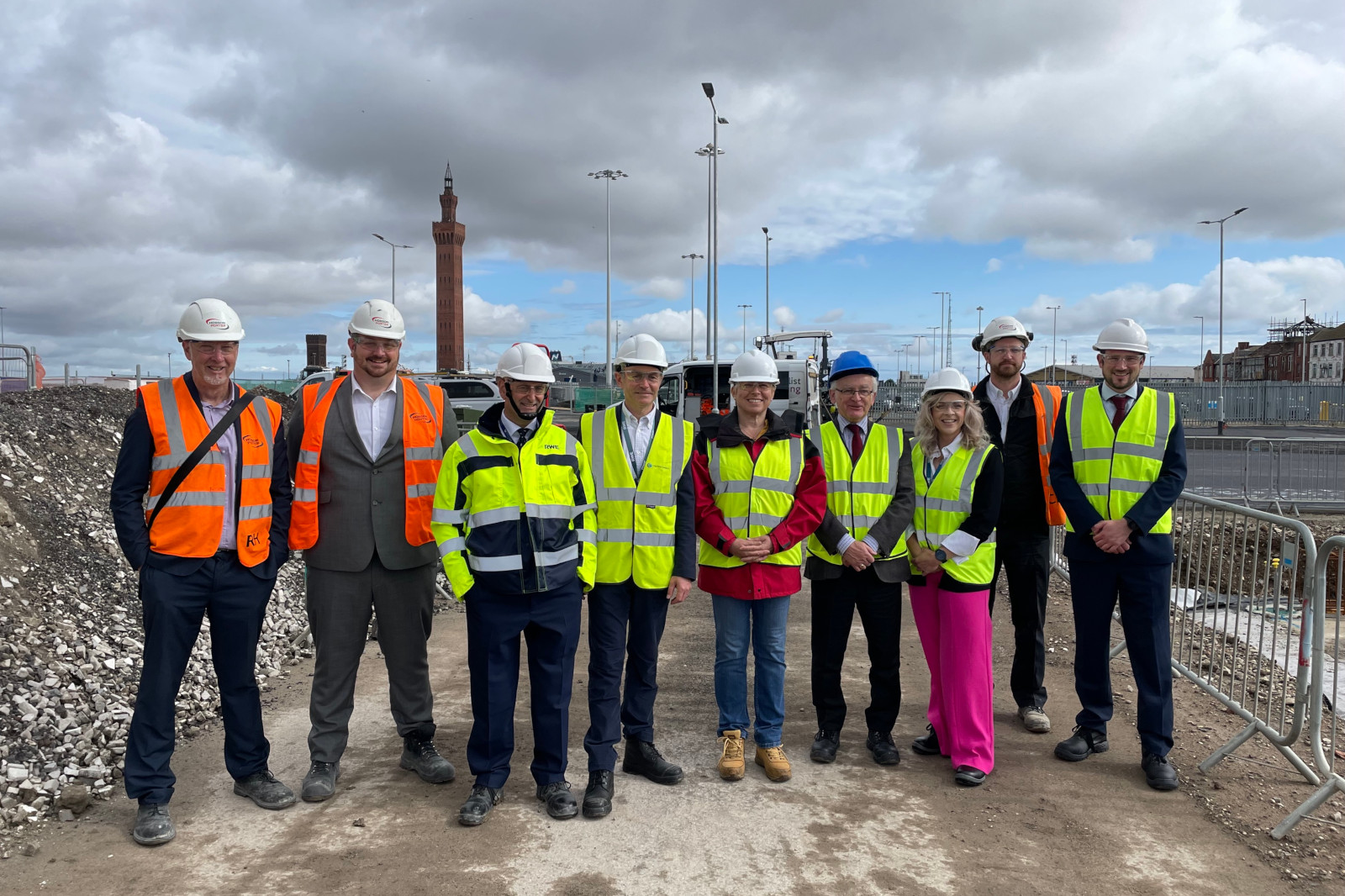 A group of individuals in high-visibility vests and helmets at a construction site.