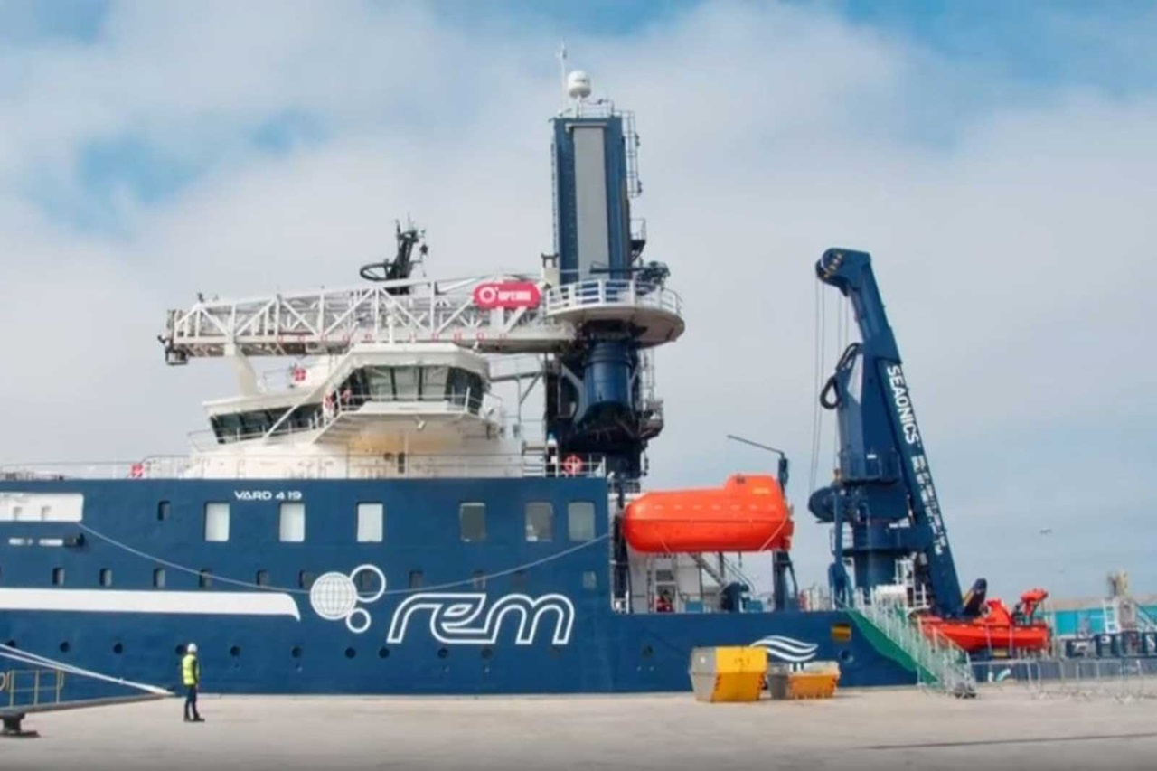 A blue vessel named VARD 4 19 docked, featuring an upper deck, rescue boat, and marine equipment.
