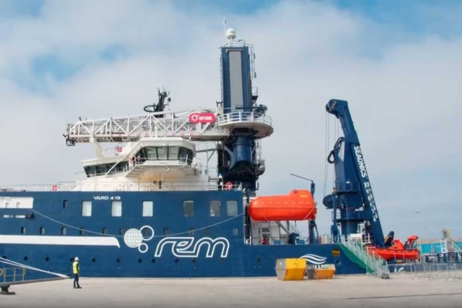 A blue vessel named VARD 4 19 docked, featuring an upper deck, rescue boat, and marine equipment.