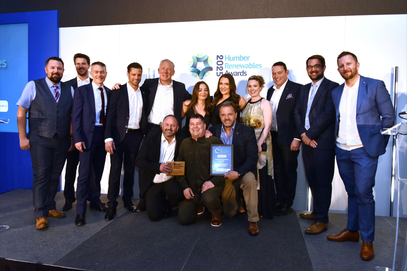 A group of award winners at the Humber Renewables Awards 2023, displaying trophies and certificates on a stage.