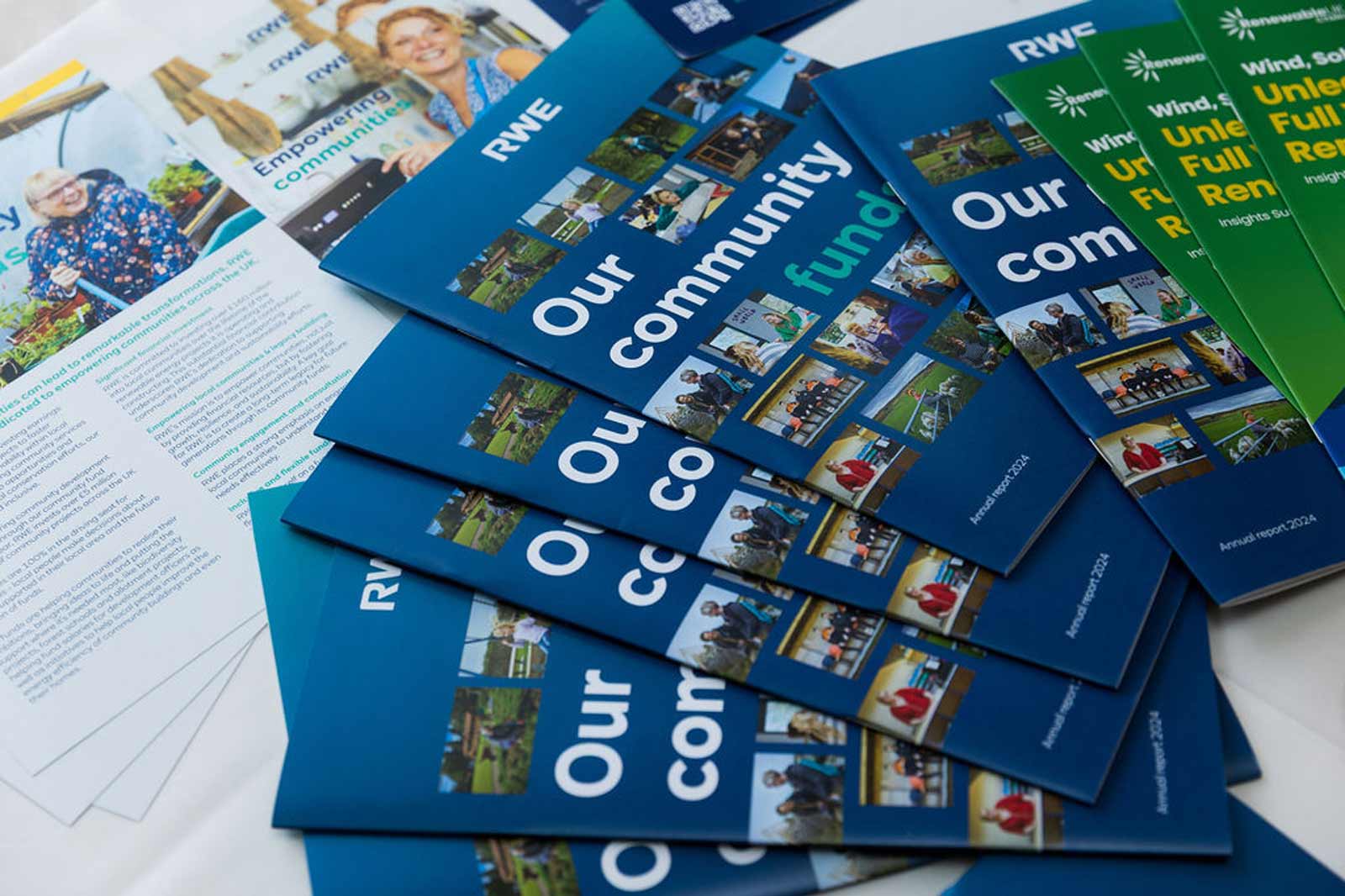 A collection of brochures and documents regarding community funding by RWE, displayed on a table.