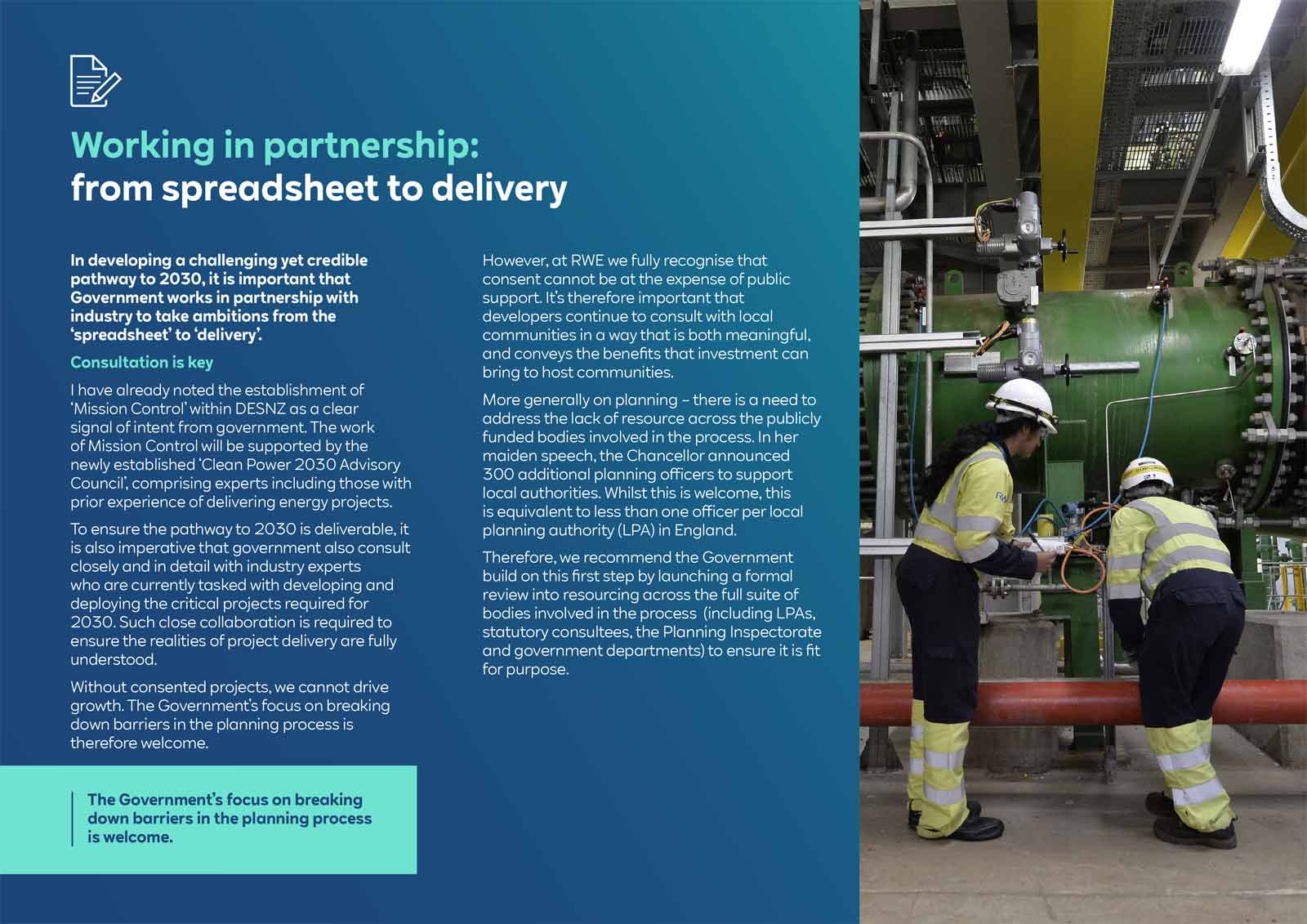 Two workers in safety gear interact with machinery in an industrial setting, discussing processes related to energy project delivery.