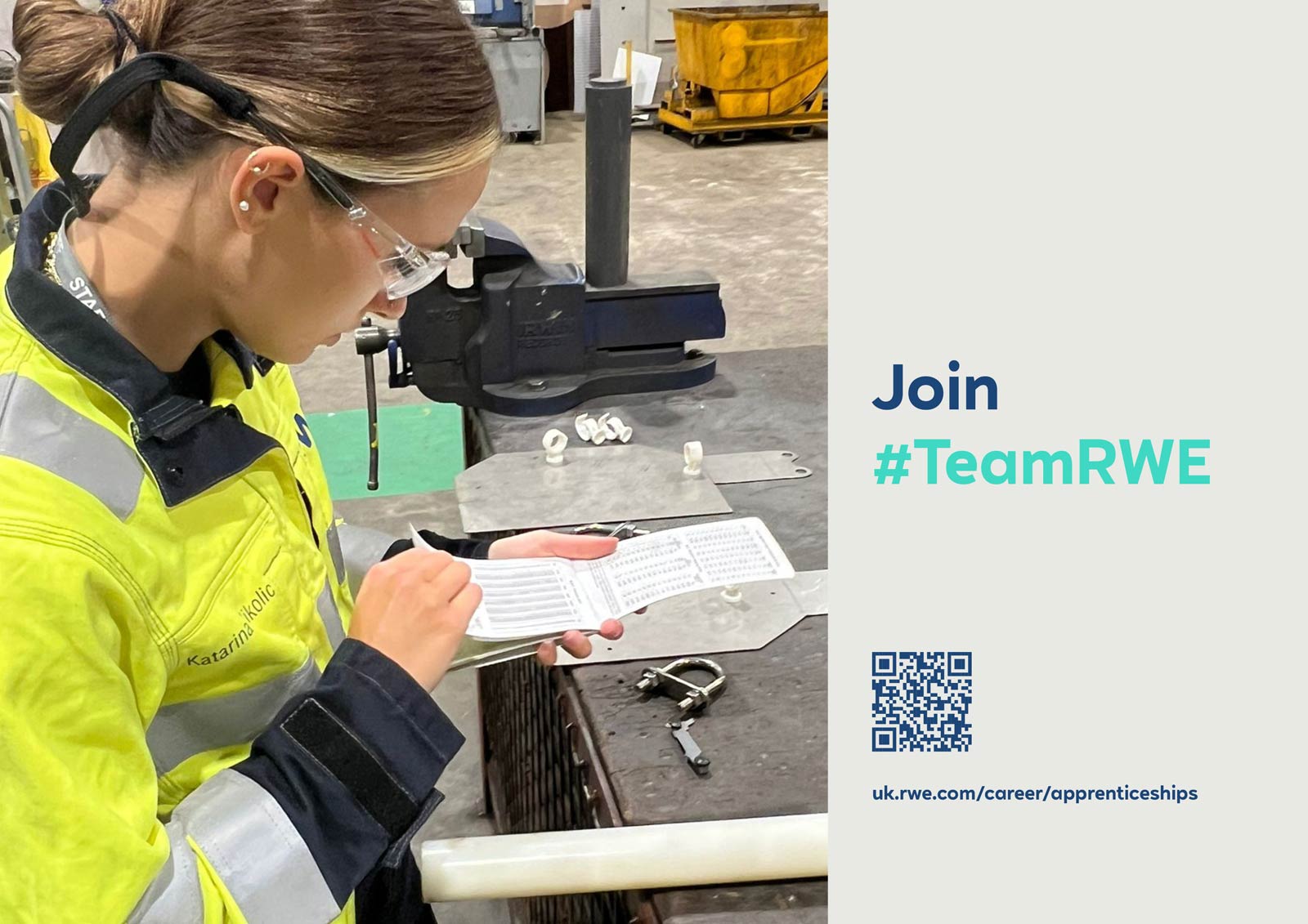 A woman in a yellow work jacket is checking a technical sheet while surrounded by tools and materials in a workshop.