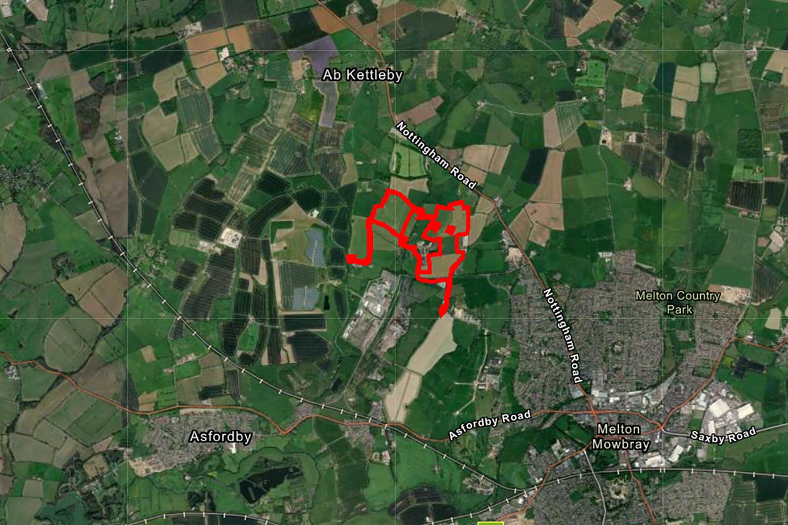 A satellite image depicting a rural landscape with fields, roads, and a marked red path in the area near Melton Mowbray.